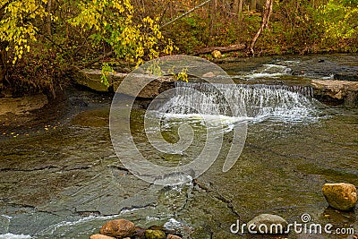 Tiny waterfall under autumn foliage Stock Photo